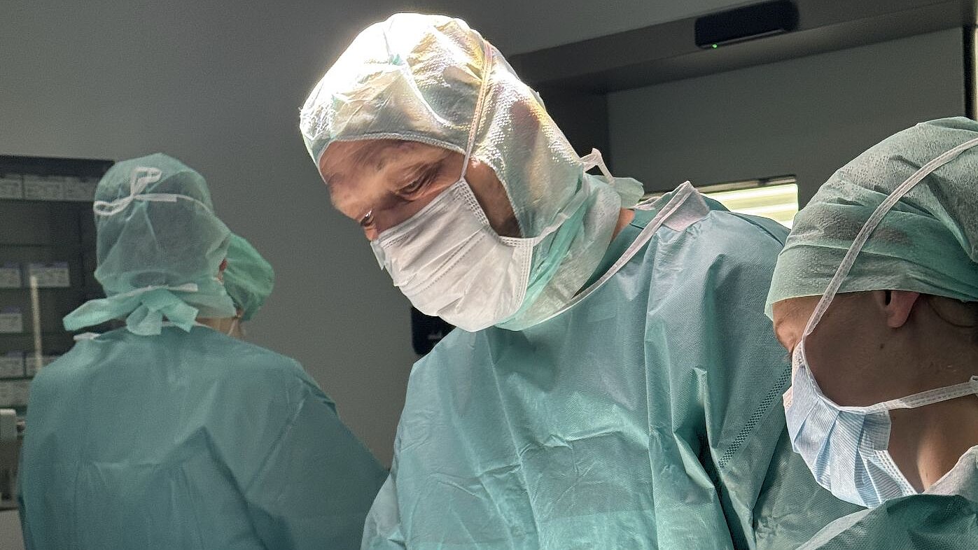 Ein Operateur und zwei Assistent beim operativen Eingriff am Schädel