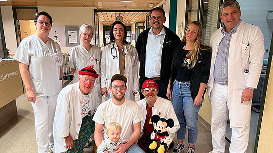 Das Team der Kinder-und Jugendmedizin mit Chefarzt Dr. Vlaho, die Klinikclowns mit der kleinen Patientin Josephine-Jodie Reinik und Papa Patrick sowie Cornelia Englmeier und Hubertus Sterflinger vom BDKJ.